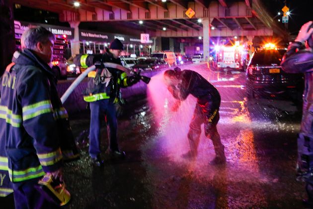 A diver is sprayed with water after working at the scene 