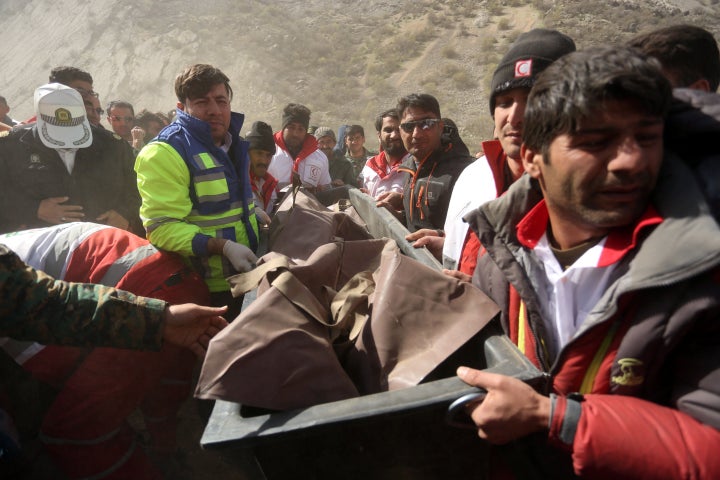 Medics and rescuers evacuate the body of a victim killed in a private plane crash in Iran, March 12, 2018. The crash killed 11 people, including a Turkish tycoon's daughter.