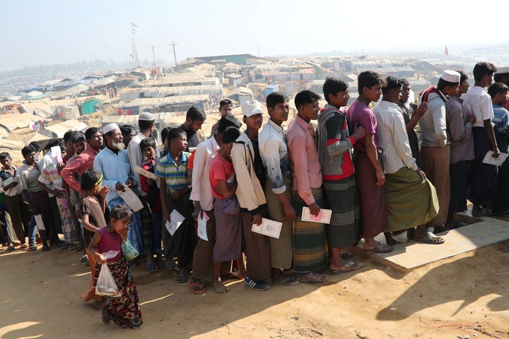 Rohingya refugees stand in a queue to collect aid supplies in Kutupalong refugee camp in Cox's Bazar, Bangladesh, January 21, 2018.