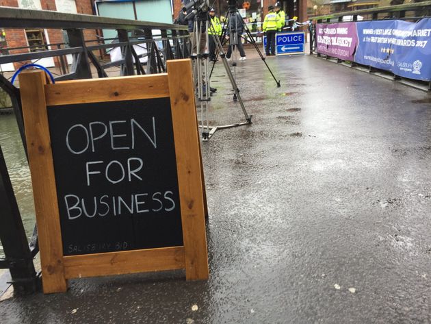 A sign reassures passersby the shops near the cordon are still open