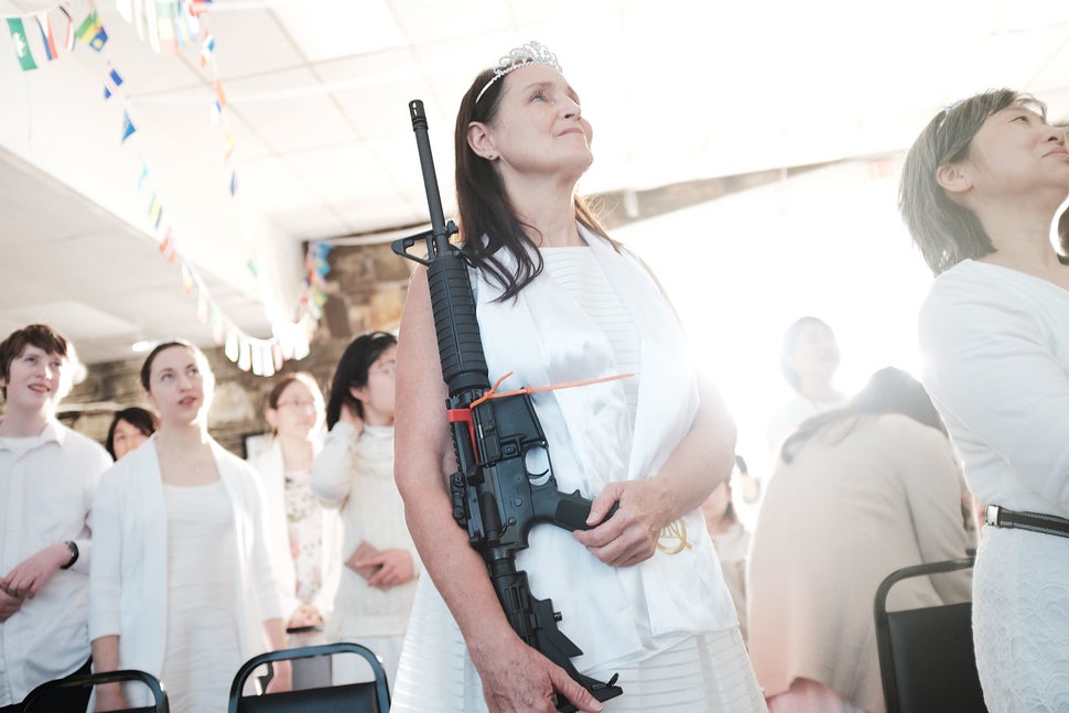 A woman holds an AR-15 rifle during a ceremony at the World Peace and Unification Sanctuary on Feb. 28 in Newfoundland,