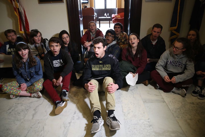 Students sit and protest in front of Senate Majority Leader Mitch McConnell's office in Washington, D.C., to urge Congress to