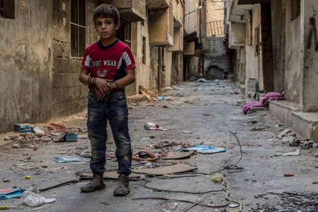 A Syian child walks through the streets of Damascus after an attack