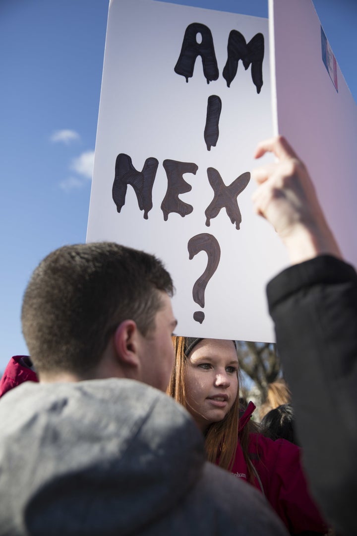 A student holds a sign reading 'Am I Next?' outside the White House on Wednesday.