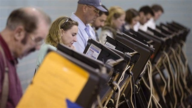 Voters use electronic voting machines at a polling place in Columbus, Ohio. Local officials across the country are trying to shore up their cybersecurity defenses ahead of the midterms in November.