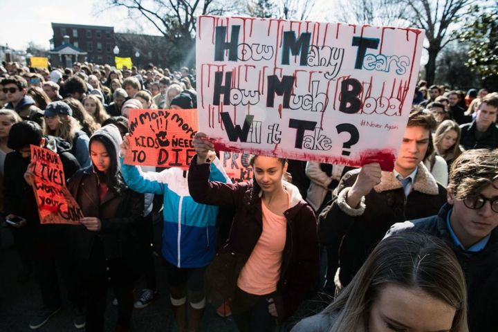 Students hold signs at Georgetown University in Washington, D.C., on March 14, 2018, during a national walkout to protest gun violence. 