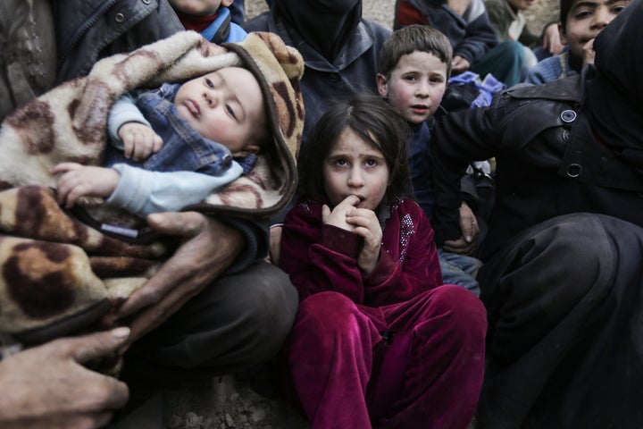 Syrian children wait to be evacuated from the eastern Ghouta enclave on the outskirts of Damascus on March 15, 2018.