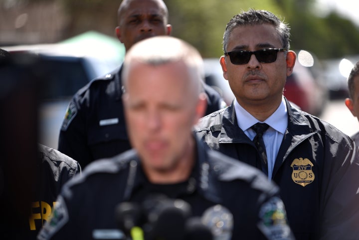 An agent from the Bureau of Alcohol, Tobacco, Firearms and Explosives watches as Manley speaks during a news conference