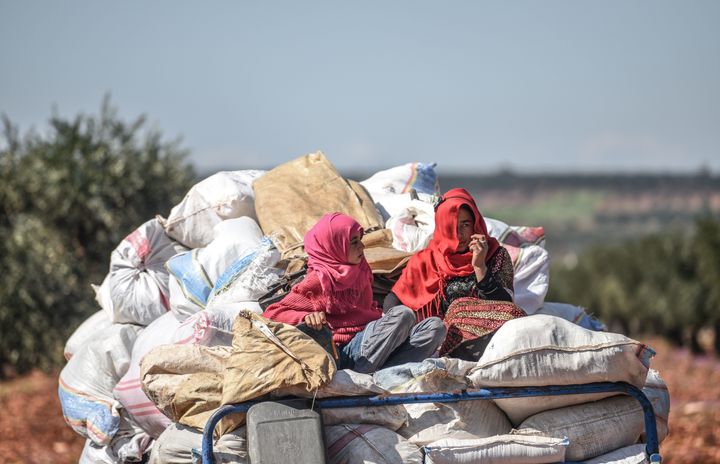 Syrian women arrive at a check point in the village of Anab ahead of crossing to the Turkish-backed Syrian rebels side on March 17, 2018, as civilians flee the city of Afrin in northern Syria. More than 200,000 civilians have fled the city of Afrin in northern Syria in less than three days to escape a Turkish-led military offensive against a Kurdish militia, a war monitor said on March 17. 