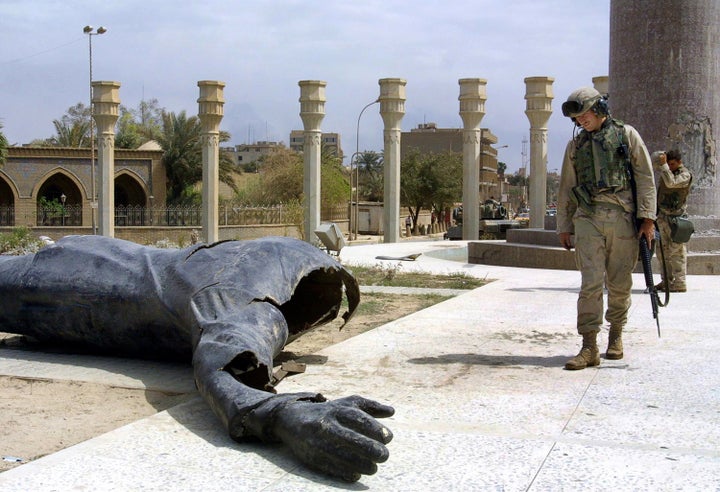 U.S. Marines walk pass a dismantled statue of Saddam Hussein on Baghdad's al-Fardous square on April 10, 2003.