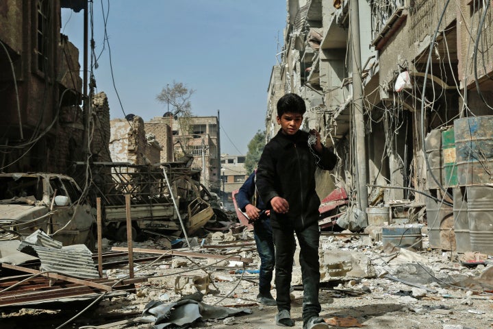 Children walk among the rubble after an airstrike in Douma, in the eastern Ghouta region of Syria, on Monday. The latest strikes killed at least 13 people overnight, the Syrian Observatory for Human Rights said. 