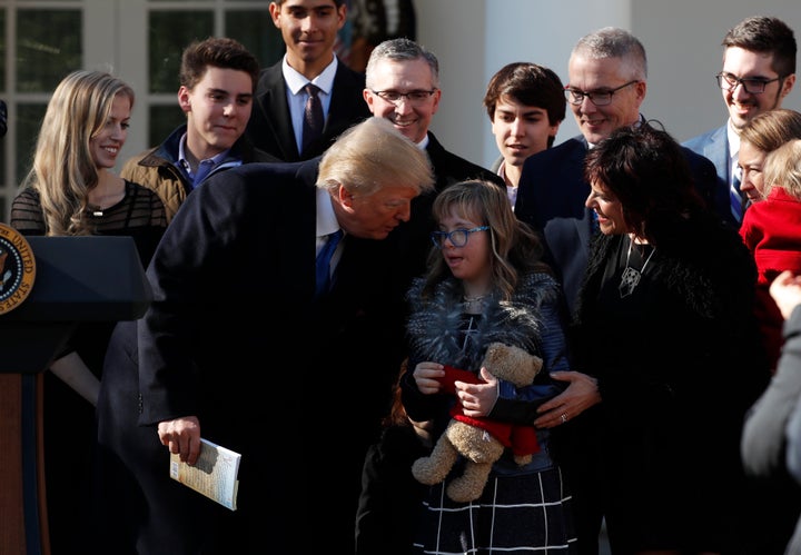 Trump greets a young girl among families gathered in the White House Rose Garden as he addresses the annual March for Life ra
