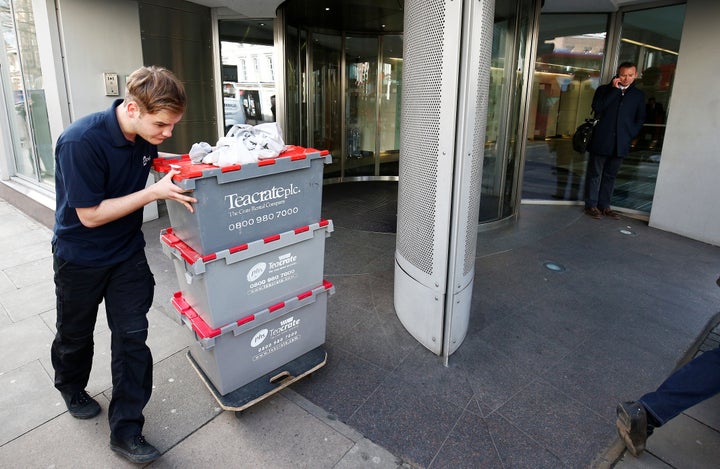 A man wheels storage crates from the building that houses the offices of Cambridge Analytica in central London, Britain, on Tuesday.