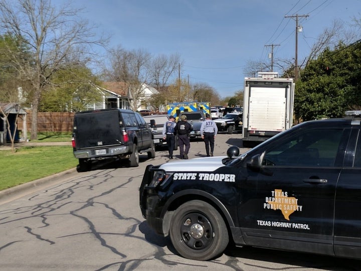 Law enforcement officers are seen blocking a street leading to the home of Mark Conditt.