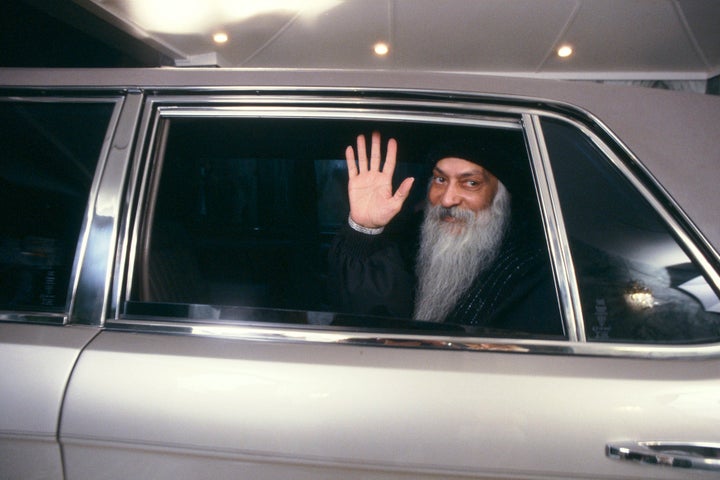 Rajneesh waving from a car.