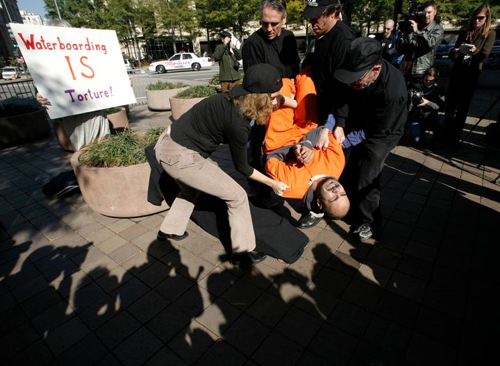 Demonstrator Maboud Ebrahimzadeh is lowered onto the board during a simulation of waterboarding outside the Justice Departement in Washington November 5, 2007. 