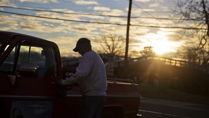 A customer gets into his car after shopping at a convenience store as the sun rises in Lula, Georgia. Rural areas gained popu