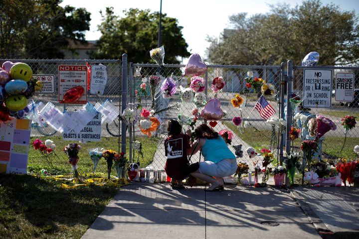 People place flowers, among other mementos, at the fence of Stoneman Douglas High on Feb. 18