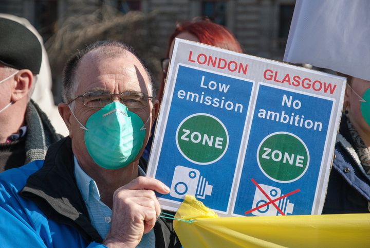 A protester looks at photographers camera during a protest over plans to tackle air pollution in Glasgow's George Square last week.
