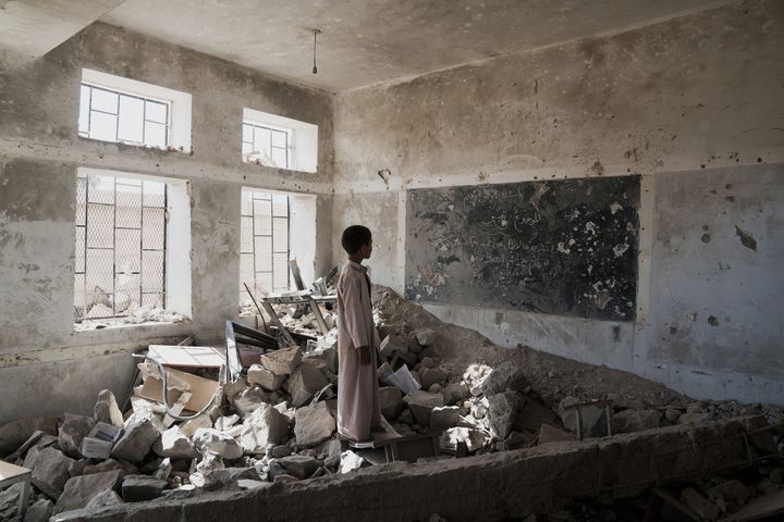 A boy stands in the ruins of his old classroom in Saada, Yemen.