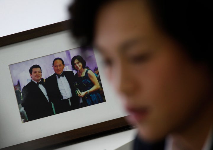 Chao poses next to a family photo of herself, her father (center) and brother Howard. 