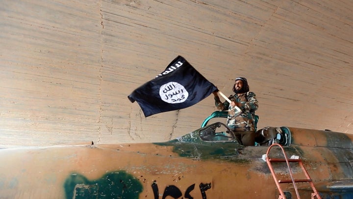 A so-called Islamic State fighter on a captured fighter jet in Syria in 2015