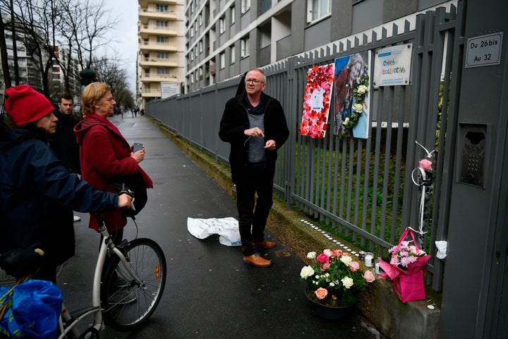 A man places a picture of Mireille Knoll on the fence surrounding her building in Paris on March 27, 2018.