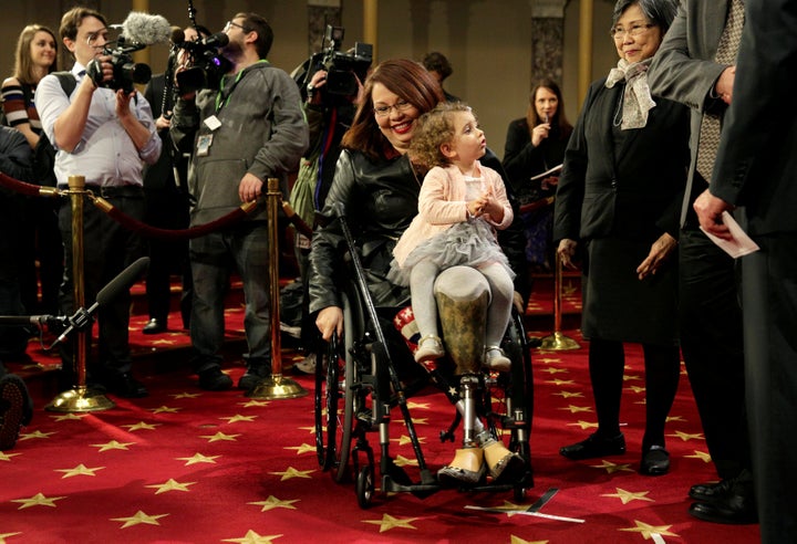 Sen. Tammy Duckworth (D-Ill.) carries her daughter, Abigail, on the opening day of the 115th Congress in January 2017.