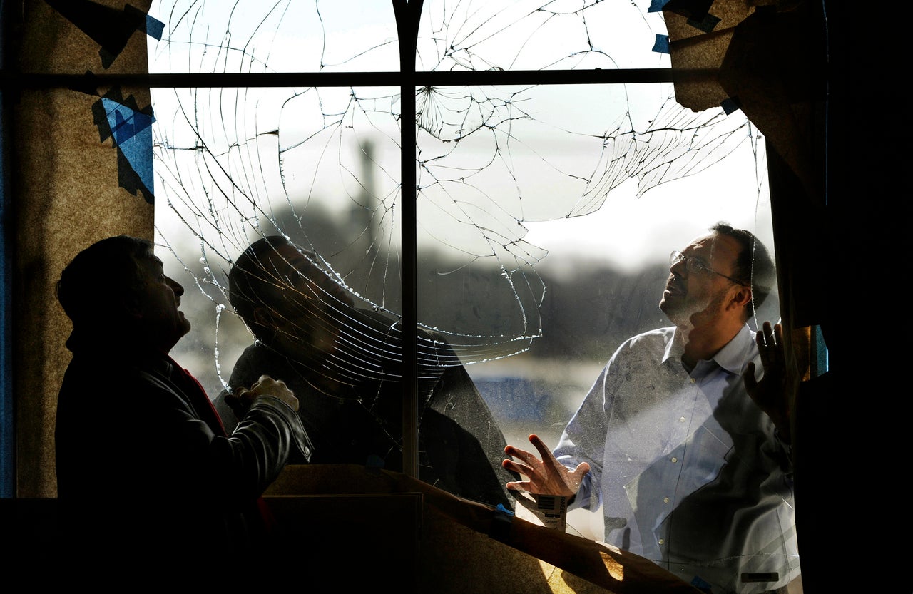 Shahid Malik, Tarek Hasan and Usman Ghumman inspect a vandalized window at the Mubarak Mosque in Chantilly, Virginia, on Feb. 17, 2012. 