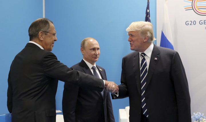 U.S. President Donald Trump shakes hands with Russian Foreign Minister Sergey Lavrov on July 7, 2017, as Russian President Vl