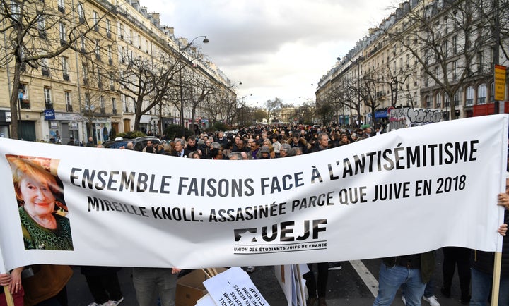 Politicians and others stand behind a banner as they prepare to take part in a slient march in Paris on Wednesday in memory of Mireille Knoll.