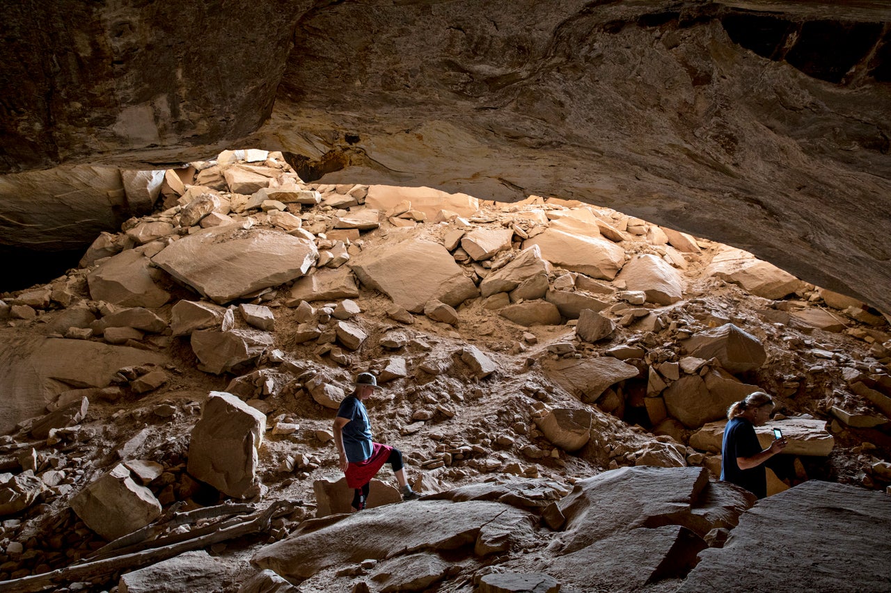 Theresa Titone, a volunteer with Friends of Cedar Mesa, right, and Erica Tucker, education manager of Friends of Cedar Mesa, walk around an alcove ruins site in Bears Ears National Monument on March 22.