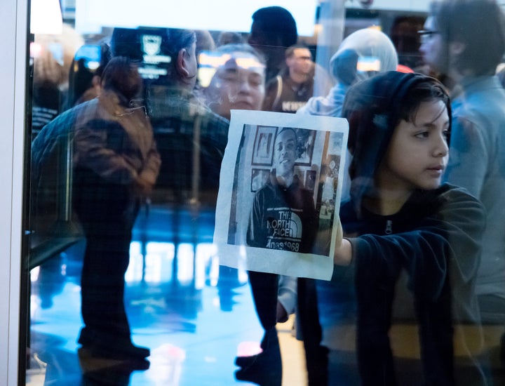 A young demonstrator holds a photo of Stephon Clark to the glass of the doors to Golden 1 Center in Sacramento, California, as protestors block the entrance to the arena on March 22.