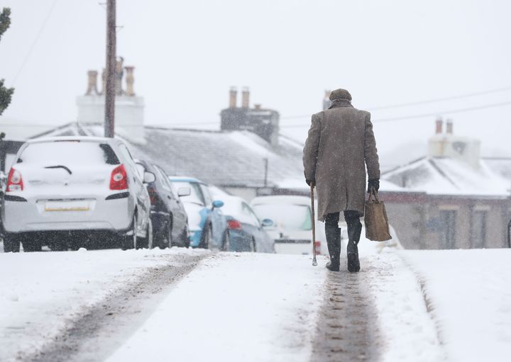 A man walks through snow in Cumbria - five weather warnings are in place this Easter Monday