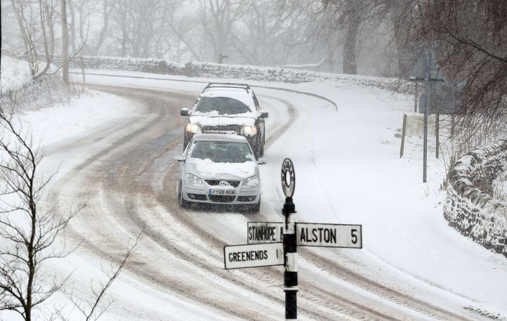 Snow has closed several roads this Easter; cars are seen driving slowly through dangerous conditions in Nenthead, Cumbria, above