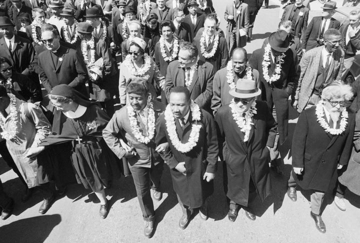 King, arm in arm with his chief aide, the Rev. Ralph Abernathy, leads marchers as they begin the Selma to Montgomery civil rights march from Brown's Chapel Church in Selma, Alabama.