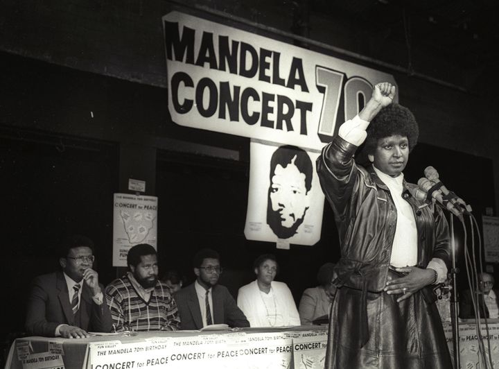 Winnie Mandela raises her fist in a black power salute after announcing that a massive pop concert will be held to mark the 70th birthday of her husband in 1988.