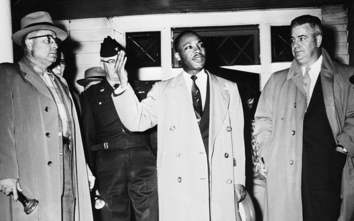 Martin Luther King Jr. urges calm from the porch of his home, which was damaged by a bomb during a boycott of the Montgomery, Ala.., bus system to protect segregation in 1956. With him, left to right, are: Fire Chief R.L. Lampley; Mayor W.A. Gayle (in uniform) and City Police Commissioner Clyde Sellers.