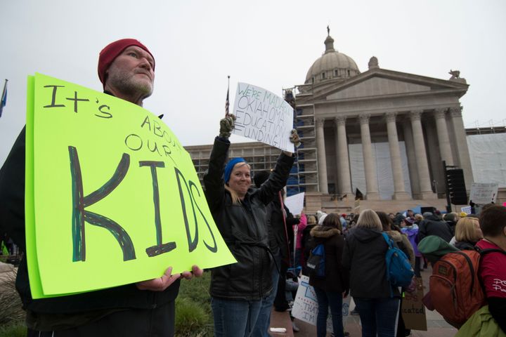 Kent Scott, a teacher from Tecumseh, Oklahoma, holds a protest sign at the state Capitol.