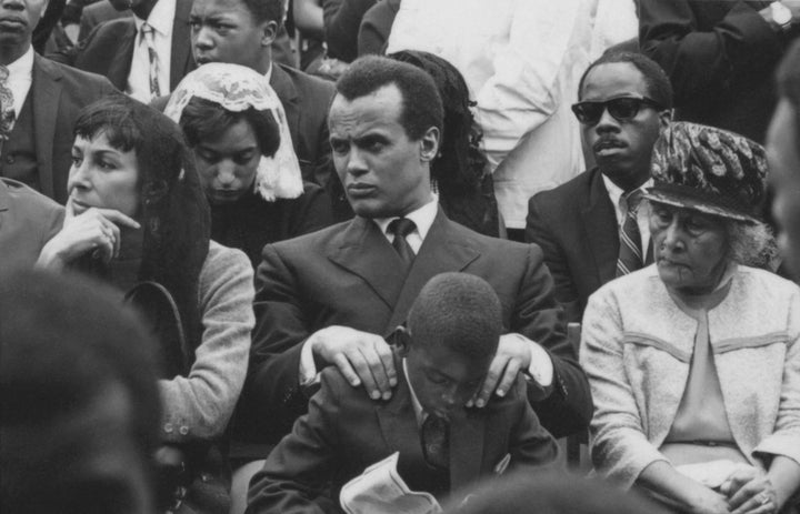 Actor, singer, and activist Harry Belafonte (center), his wife, Julie Robinson (left), and his son, David (seated in front of Belafonte), at the public memorial for Dr. King at Morehouse College. 