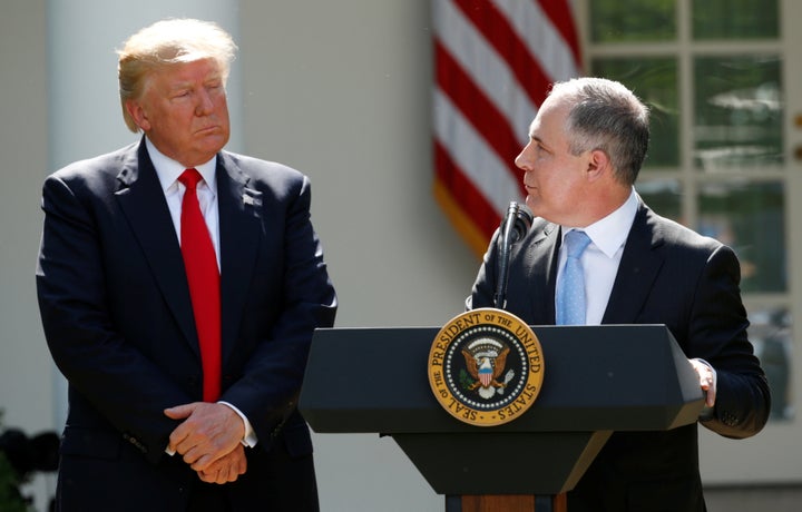 President Donald Trump listens to Scott Pruitt in the White House Rose Garden after announcing his decision to leave the Paris agreement in June 2017.