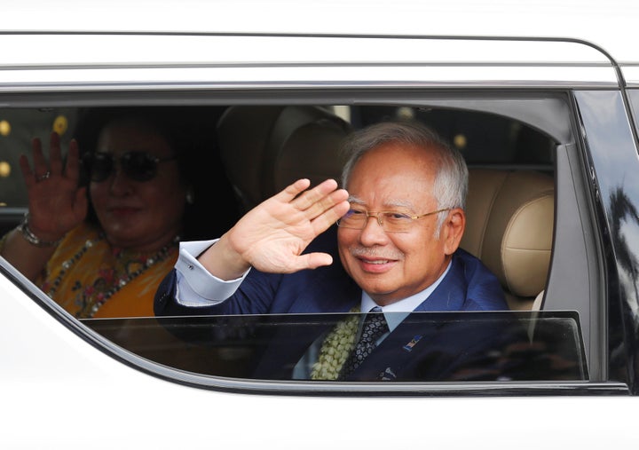 Malaysian Prime Minister Najib Razak and wife Rosmah wave to the crowd upon their arrival to attend the Association of Southe