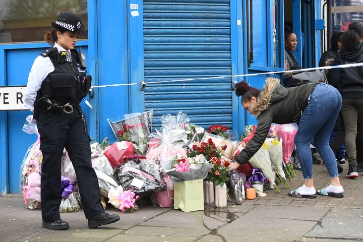 A woman lays flowers on Chalgrove Road, Tottenham, north London, where a 17-year-old girl has died after she was shot Monday evening.
