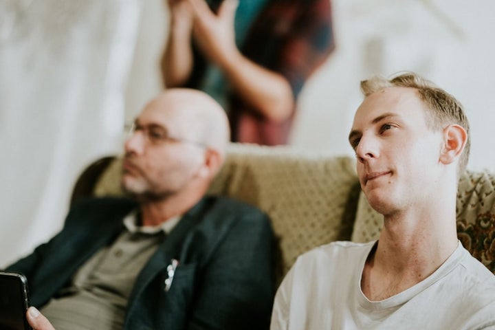 Agnew's brother and father are seated inside the bridal shop. Her brother Cal, right, gives an appraising look to the wedding gown options.