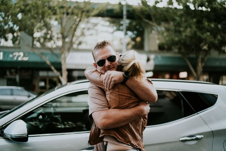 Campbell and Agnew hug outside of the bridal shop, where he dropped off her and her family for their appointment. Campbell, facing the camera and wearing aviator sunglasses, has his back to the bridal shop.