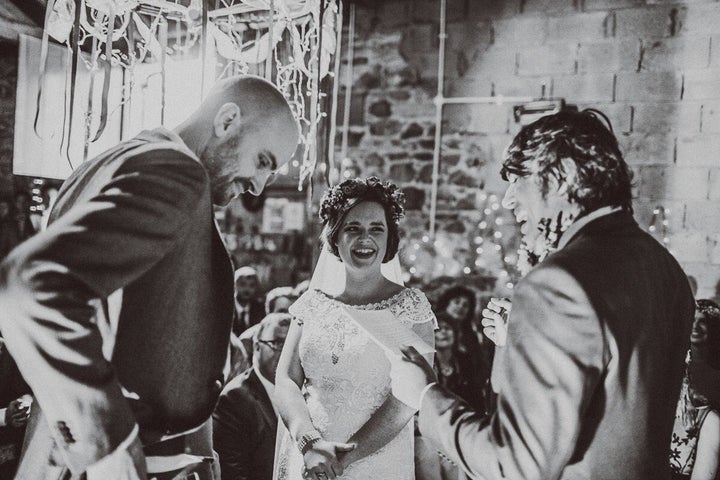 Dinesh Mehta officiating with bride, Tommy, and groom, Mike.