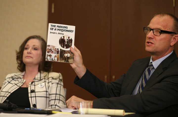 Attorney Craig Vernon holds up a book by Joseph L. Bishop at a news conference on April 5, 2018, in Salt Lake City.