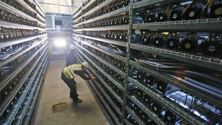 Workers look over racks of bitcoin data miners during construction of a bitcoin data center in Virginia Beach, Virginia. While some places are shunning mining companies, others are embracing any blockchain-related new businesses. Steve Helber/AP