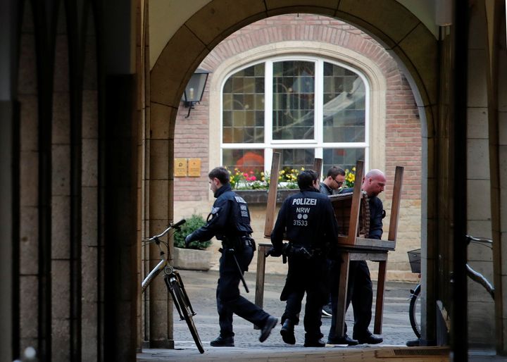 Police carry restaurant tables in front of the traditional guesthouse 'Grosser Kiepenkerl', where a man drove a van into a group of people sitting outside the popular restaurant in the old city centre of Muenster.