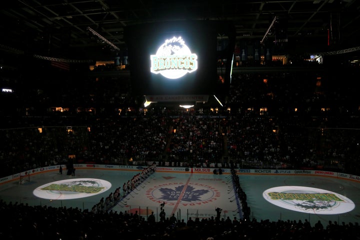 The logo of the Humboldt Broncos is displayed on the ice and scoreboard during a moment silence before a game between the Mon